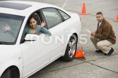 African teenager running over traffic cone at drivers test Stock Photos
