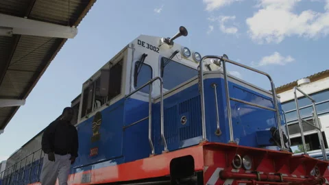 African train driver gets on the train and enters the cab,Tanzania Stock Footage 131942754