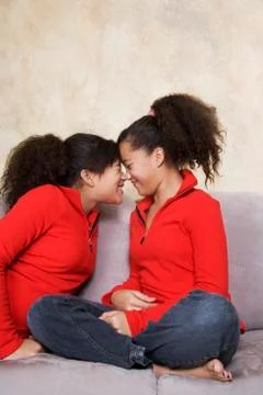 African twin sisters rubbing noses Stock Photos
