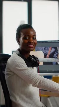 African video editor looking at camera smiling editing video project Stock Photos