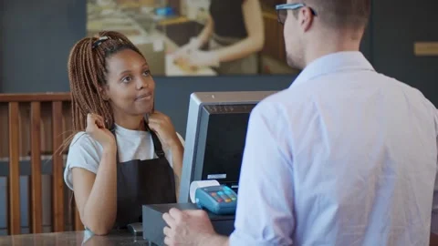 African waitress taking order of customer at bar counter typing on computer with Video stock 134546519