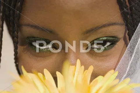 African woman with flower in front of face Stock-Fotos