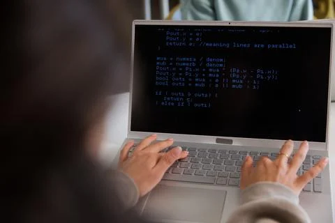 African woman with peer typing code on silver laptop at workspace, beige Photos