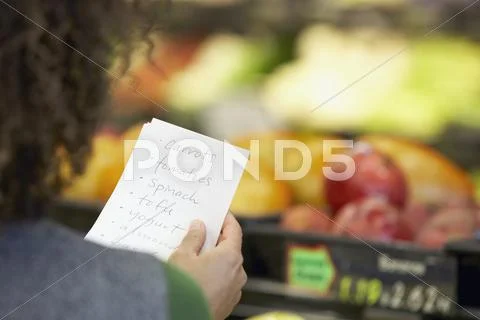 African woman reading grocery list Stock-Fotos