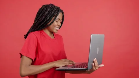 African woman smiling while using a laptop Stock Footage 241756073
