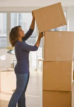 African woman stacking moving boxes Stock Photos