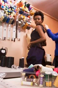 African woman trying on dress at seamstress shop Stock Photos