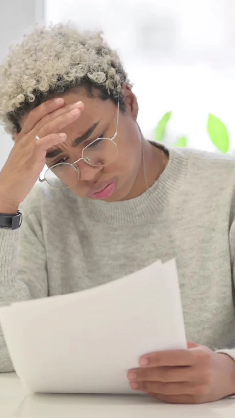 African Woman Upset while Reading Documents in Office, Vertical Video Stock Footage 337350416