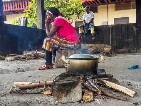 African women cooking meal over simple wood fire at Albert Schwe Stock Photos