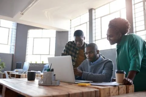 African work colleagues using a laptop together in an office Stock Photos