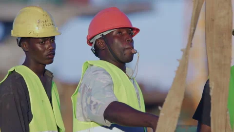 African worker directing crane at construction site,Tanzania  Africa Stock Footage