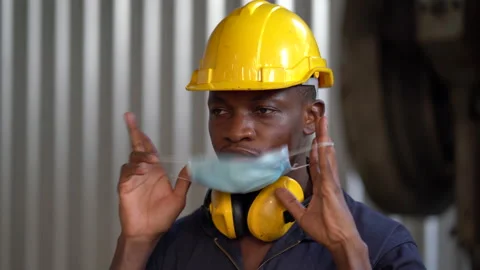 African worker man take off protective face mask End of Coronavirus or Covid- Stock Footage 154487310