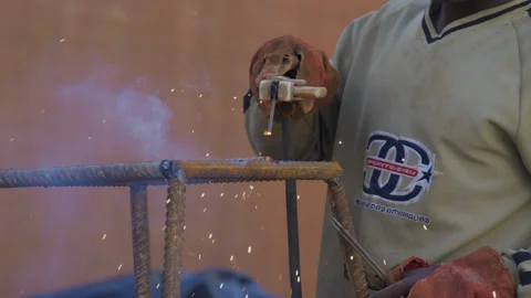 African worker operating electric welding at construction site, Tanzania  Africa Stock Footage 132328717