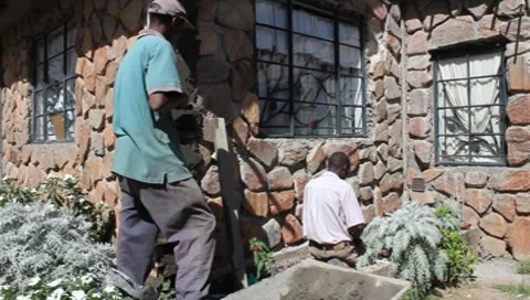 African Workers Plastering Stone Wall  (HD) Stock Footage 8830589