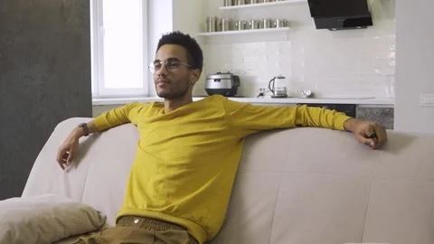 African young guy laughs watching tv Stock Footage 179967338