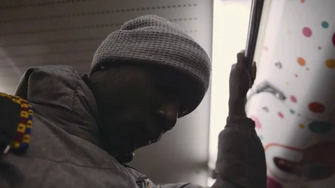 African young man in a grey cap and jacket is riding the subway. Stock Footage 102437668