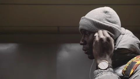 African young man inserts the earpiece into his ear Stock Footage 102437826