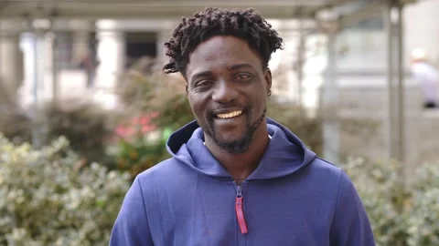African young man smiling at camera wearing a blue sweatshirt Video stock 218602112