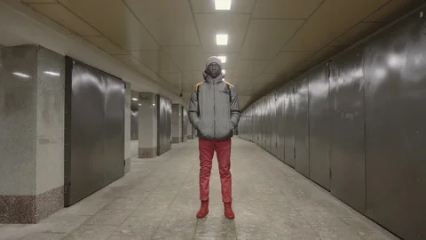 African young man stands alone at night in empty underpass Stock Footage 102437664