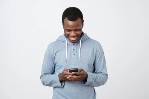 African young man using mobile phone chatting in internet with her friends. Stock Photos