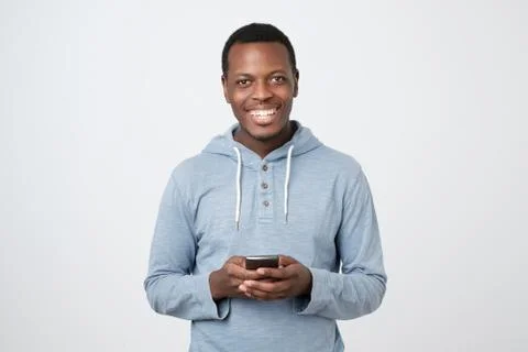 African young man using mobile phone chatting in internet with her friends. Stock Photos