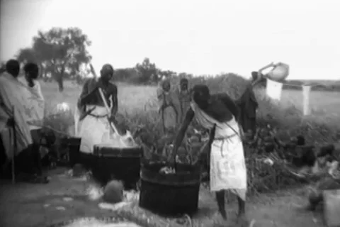 Africans stands in queue and collects food in a sack - 1962 Video stock 108990631