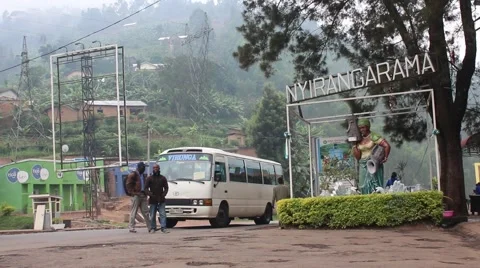 Africans walking around at base of Rwandan hills on cloudy day Stock Footage 47885583
