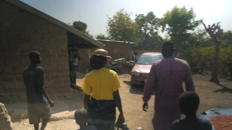 Africans Walking through a Dirt Compound co Stock Footage 115728779