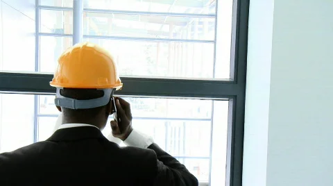 Afro-American architect studying a building and talking on phone Stock Footage