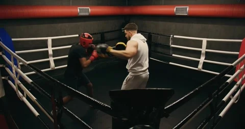 Afro American boxer in gloves is training with a coach in the boxing ring Video stock 275276995