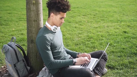 Afro american cute guy is sitting on plaid and learning online Stock Footage 101795485