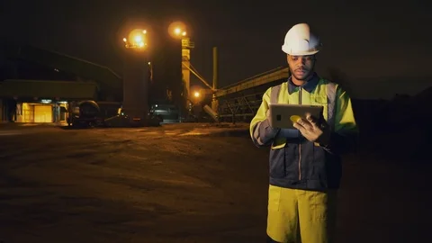 Afro-american engineer using digital tablet working night shift at quarry Stock Footage 124067631