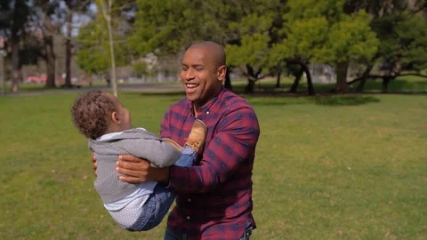Afro-american father throwing up son into air, child laughing Stock Footage 104746152