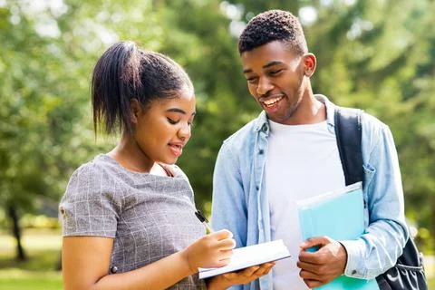 Afro american friends sharing knowledge in the university campus at sunny day Stock Photos