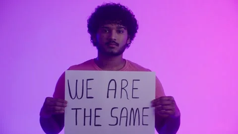 An afro american guy activist with a direct confident gaze shows poster with Stock Footage 262465814