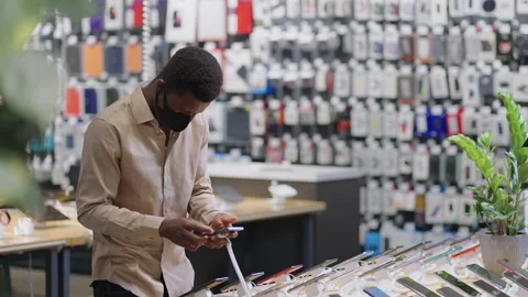 Afro-american guy is shopping during pandemic of covid-19 in digital equipment Stock Footage 153131654