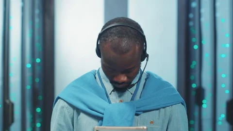 Afro-american IT engineer raising head looking at camera holding digital tablet Stock Footage 119783487