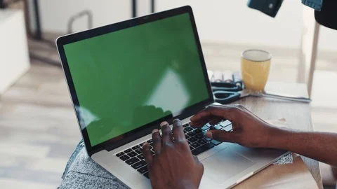 Afro-American male hands using laptop with green screen standing on a table Stock Footage 87028702