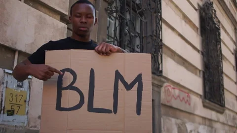 Afro american man holding a makeshift poster with the inscription BLM. Black Stock Footage 135352303