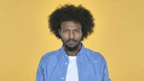 Afro-American Man Looking at Camera on Yellow Background Stock Footage 99216668