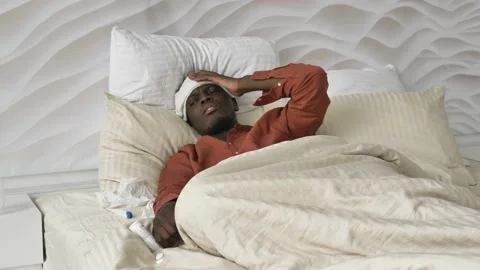 Afro-American man with patch on head pills and thermometer Stock Footage 153986024