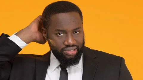 Afro-American man scratching head and shrugging shoulders, trichology problems Stock Footage 104699689