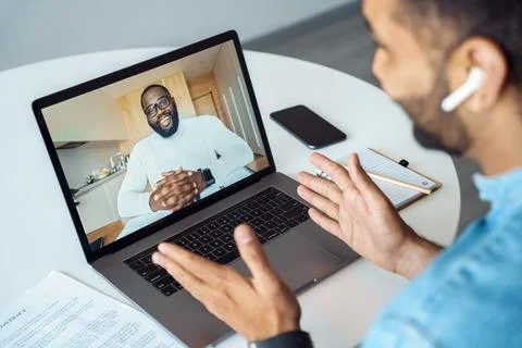 Afro american man talking using webcam internet connection, view over shoulder Stock Photos