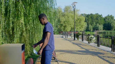 Afro-American man throws it into trash can face mask, shows plaster on shoulder 스톡 동영상 159812003