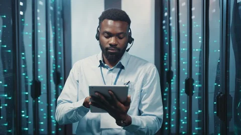 Afro-american server engineer using digital laptop running maintenance test with Stock Footage 119081672