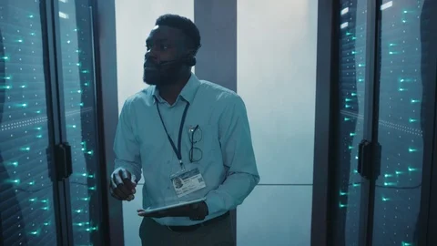 Afro-american server specialist using tablet inspecting computer hardware in Stock Footage 119081901