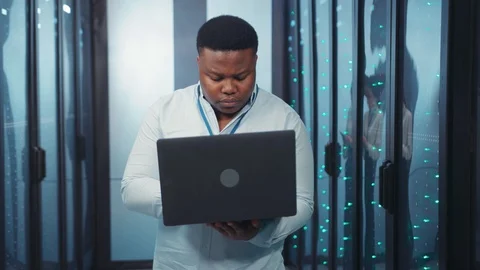 Afro-american smart system administrator working busy on laptop doing backups Stock Footage 119782588