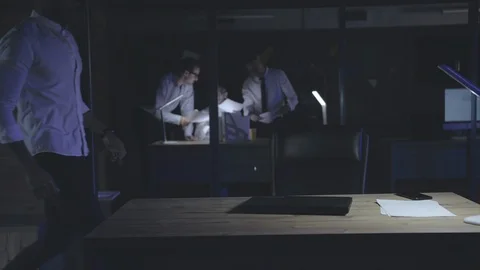 Afro-american worker using computer at his desktop at nighttime Stock Footage 125689037