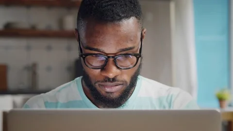 Afro-american young businessman using laptop at home. Video stock 133045360