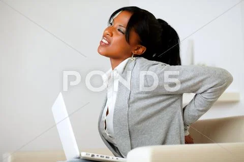 Afro-american young woman with back pain Stock Photos
